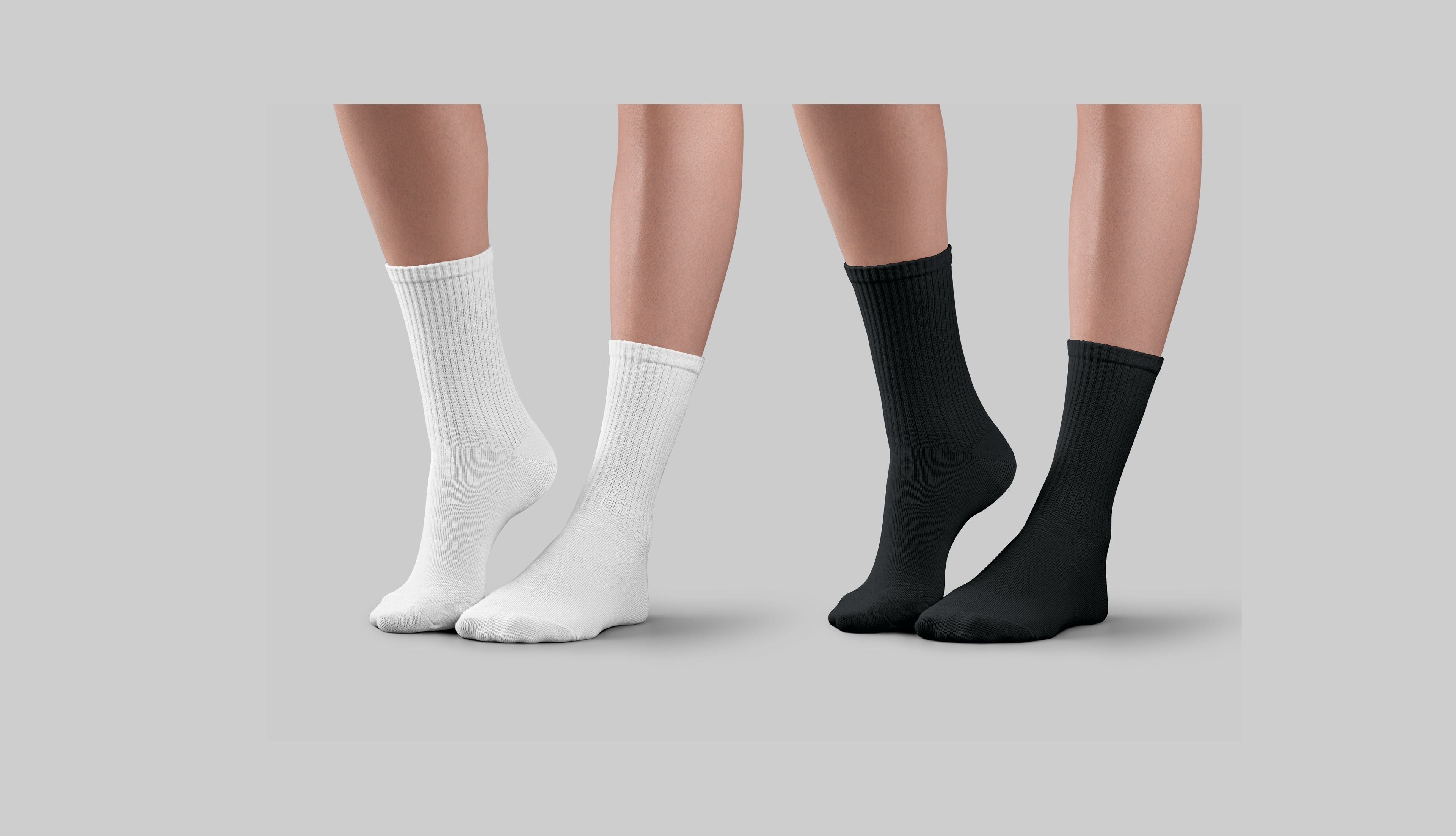 Two pairs of white socks and two pairs of black socks on a neutral background