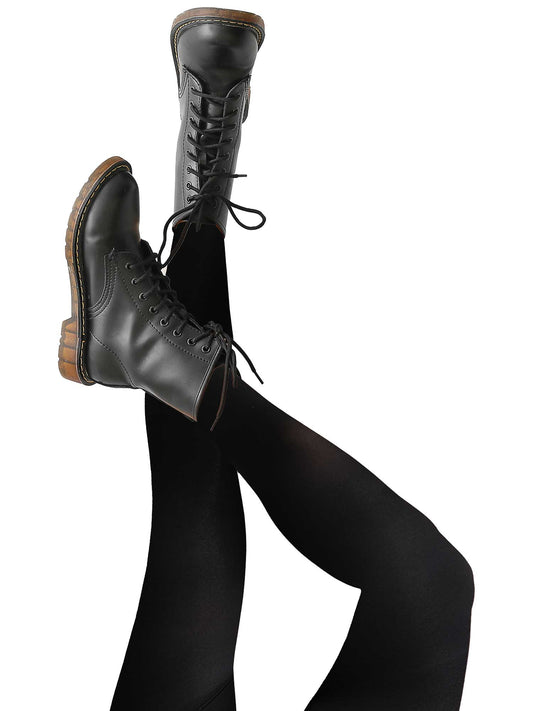 Woman lying on back with legs raised, wearing black fleece-lined tights and lace-up combat boots, showcasing cozy thermal leggings for winter fashion, casual streetwear, and cold-weather layering