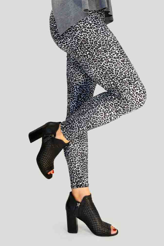 Woman wearing high-waisted brown cheetah print leggings paired with a black sports bra. Comfortable and stretchy animal print leggings perfect for workouts, yoga, or casual wear. Full-length design with a body-hugging fit, photographed barefoot in a studio with a neutral background.