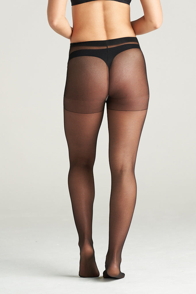 Woman modeling light support sheer hosiery in black tone, standing in a graceful back pose with one leg lifted, showcasing the smooth, semi-transparent finish and high-waisted support band
