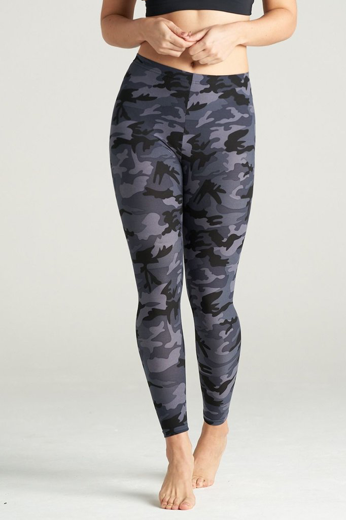 Woman wearing high-rise grey camouflage leggings with a sleek fit, paired with a black sports bra. She stands barefoot on a neutral studio backdrop, showcasing the leggings' bold grey, black, and charcoal camo pattern. Ideal for fitness, yoga, and everyday activewear.