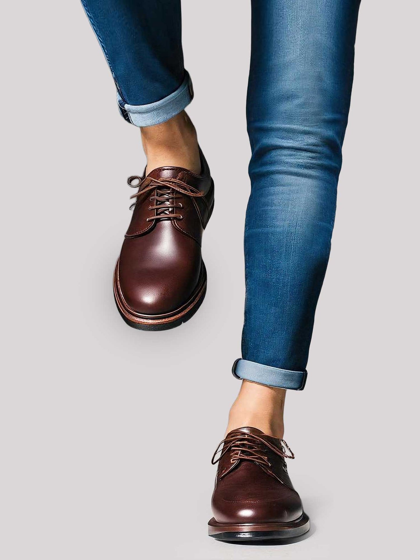 Man walking forward in cuffed blue jeans and brown leather dress shoes with invisible loafer liner socks, styled for business casual or smart weekend looks